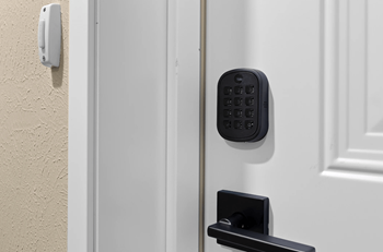 A white door with a black handle and a keypad lock.